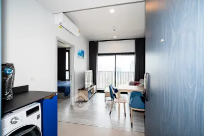 Modern apartment interior with open layout, featuring a cozy living area and dining space with city view.