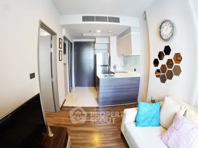 Modern living room with open kitchen, stylish decor, and cozy seating area.