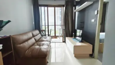 Modern living room with sleek furniture and large windows offering natural light.