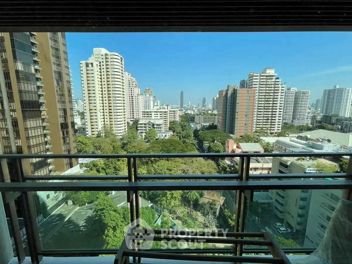 Stunning cityscape view from a high-rise balcony with lush greenery and modern buildings.
