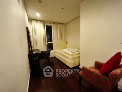 Cozy bedroom with elegant decor and city view, featuring a plush bed and stylish armchair.