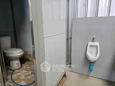 Basic bathroom with toilet and urinal in a simple setting.
