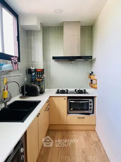 Modern kitchen with gas stove, oven, and sleek cabinetry in a compact layout.