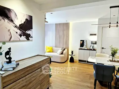 Modern living room with stylish decor and open layout, featuring wooden flooring and contemporary furniture.