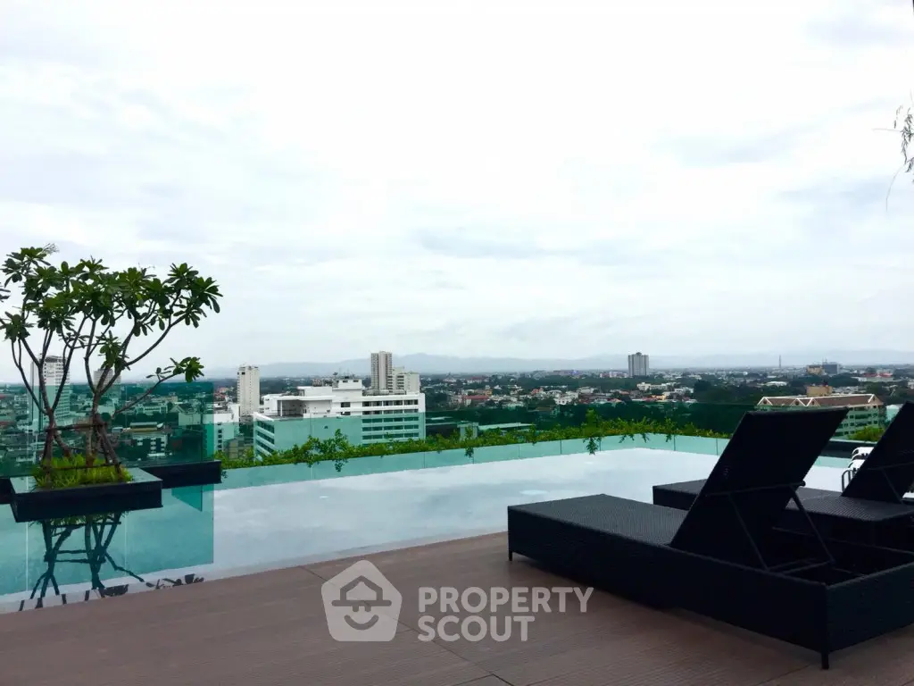 Luxurious rooftop pool with stunning city skyline view and modern lounge chairs.