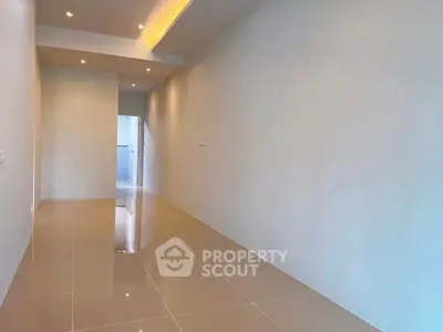 Spacious hallway with glossy tiled flooring and recessed lighting