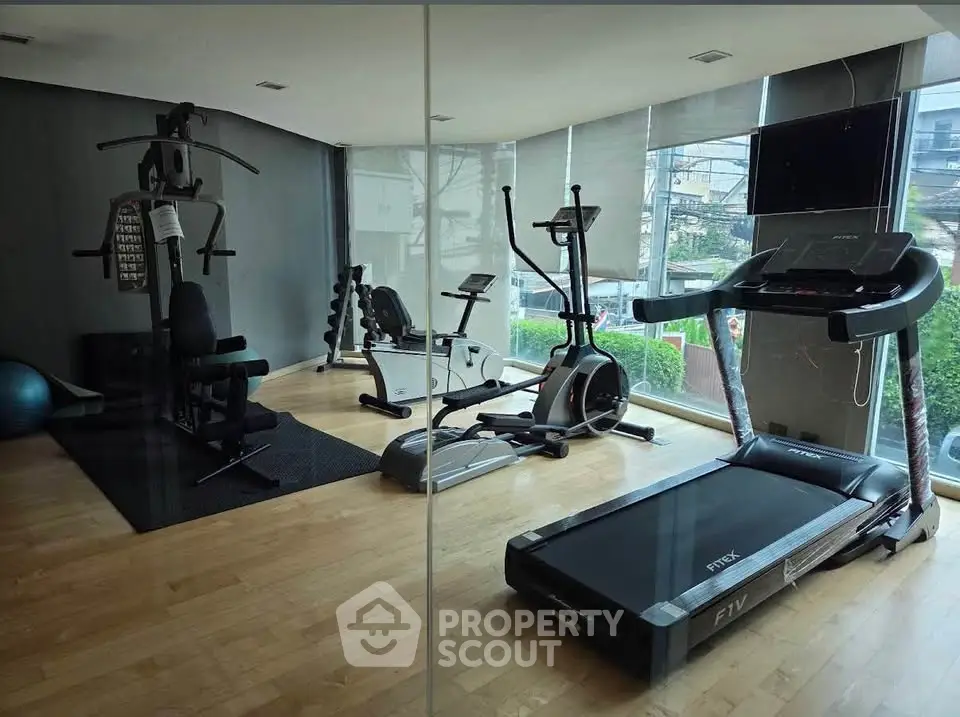 Modern gym with state-of-the-art fitness equipment and large windows offering a scenic view.