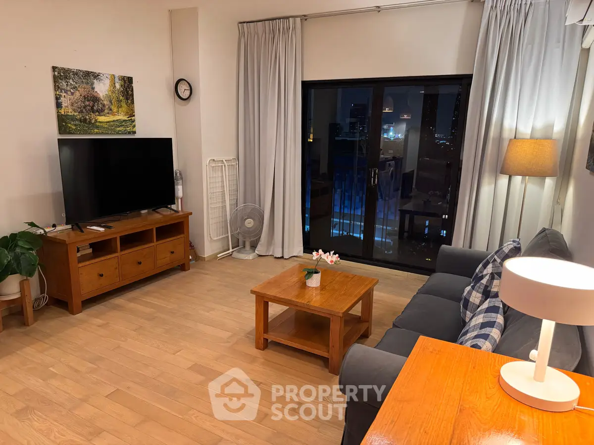 Spacious living room with modern decor and city view, featuring wooden furniture and cozy lighting.