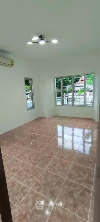 Spacious empty room with large windows and tiled floor, perfect for customization.
