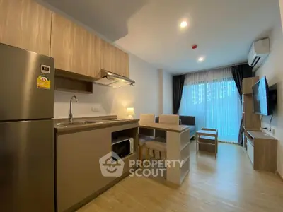 Modern open-layout kitchen and living area with sleek design and natural light.