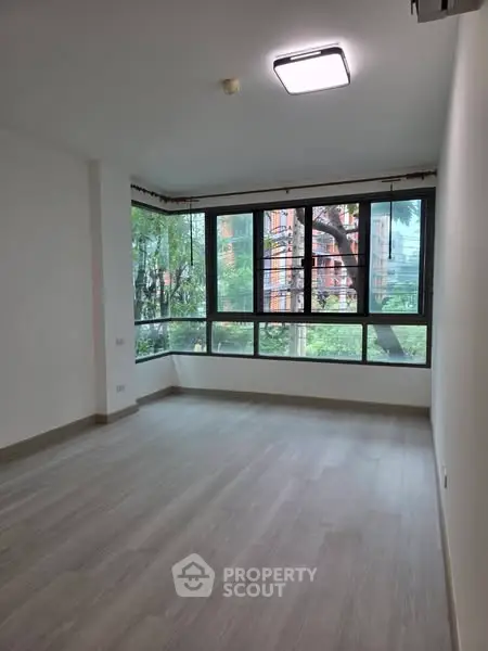 Spacious corner unit with large windows and serene garden view