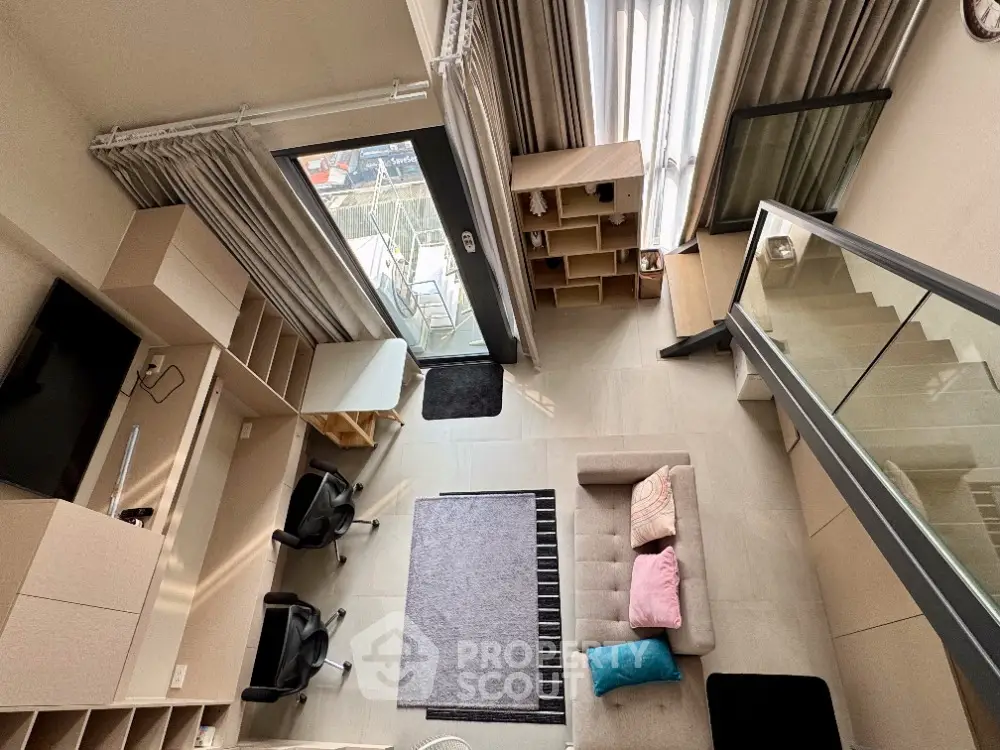 Modern loft apartment with stylish interior and mezzanine level, featuring a cozy living area and large windows.
