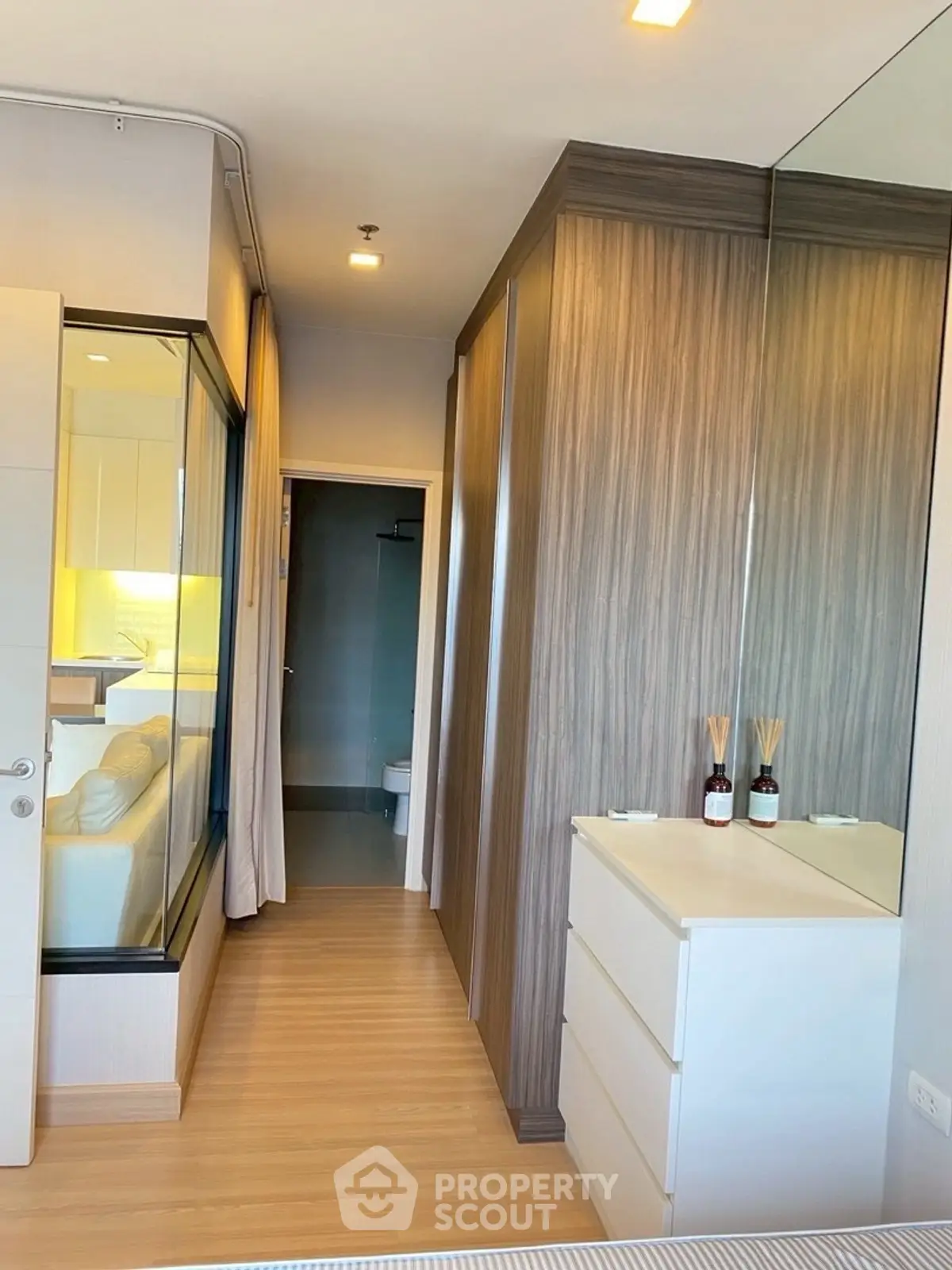 Modern bedroom with wooden flooring and mirrored wardrobe in stylish apartment