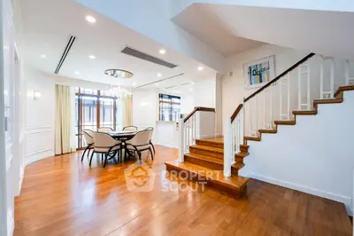 Luxurious open-plan living area with elegant staircase and dining space