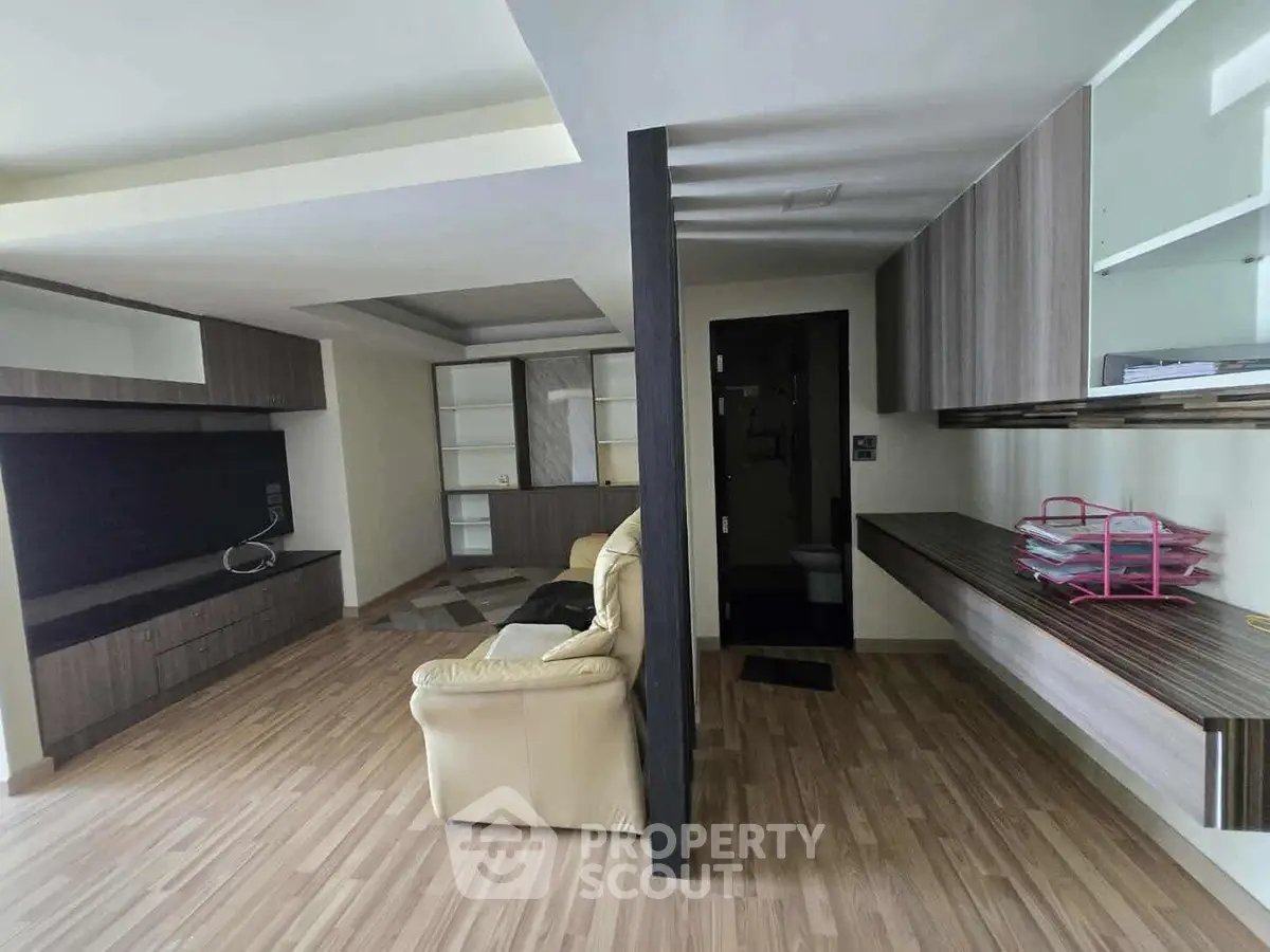 Spacious living room with modern wooden flooring and built-in storage units, perfect for contemporary living.