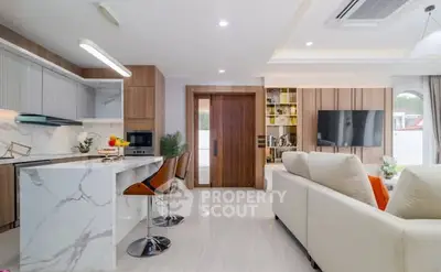 Modern open-plan living room and kitchen with marble island and stylish decor