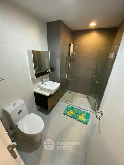 Modern bathroom with glass shower and sleek fixtures in a stylish apartment.