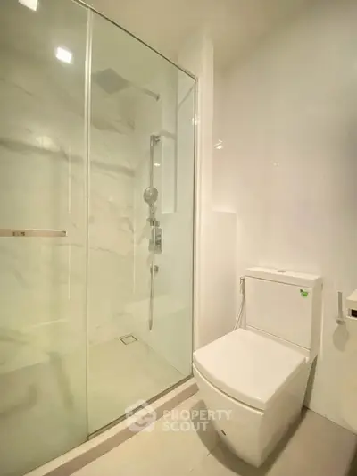 Modern bathroom with glass shower and sleek toilet design.