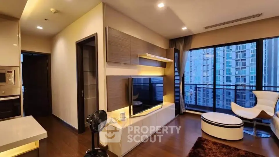 Modern living room with large windows and stylish furniture in a high-rise apartment.