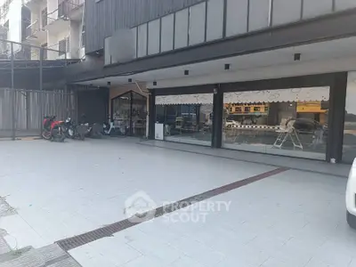 Spacious commercial property with large glass windows and ample parking space, ideal for business opportunities.