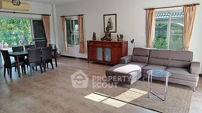 Spacious living room with modern furniture and garden view, perfect for family gatherings.