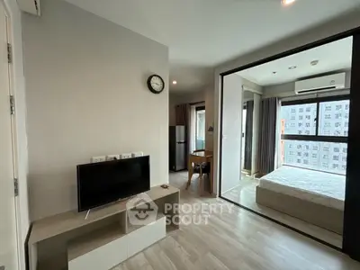 Modern apartment interior with open layout, featuring a cozy living area and bedroom with city view.