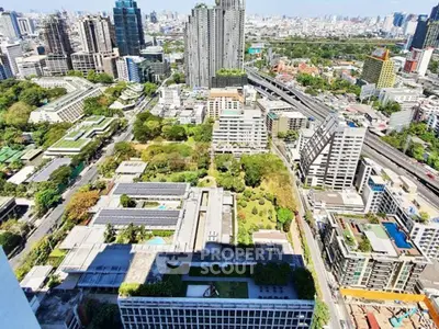 Stunning aerial view of urban skyline with lush green spaces and modern high-rise buildings.