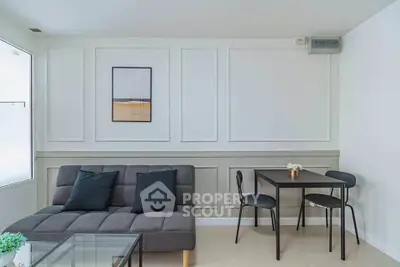 Modern living room with stylish sofa and dining set in a bright, minimalist interior.