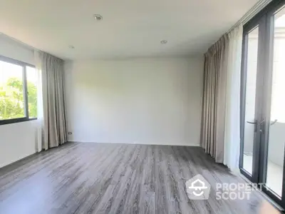 Spacious empty room with large windows and elegant flooring