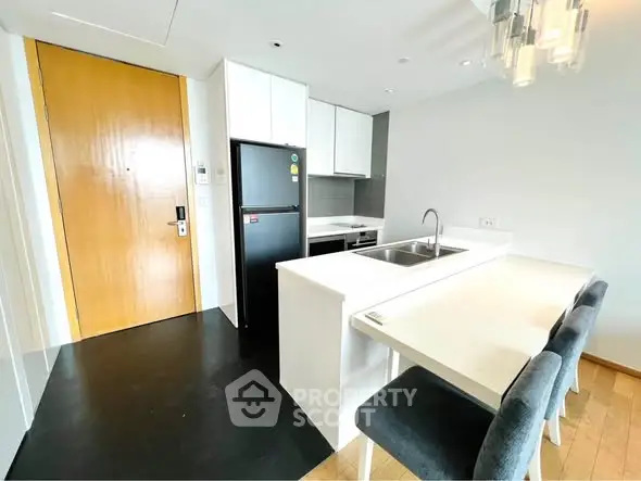 Modern kitchen with sleek design, featuring a breakfast bar and stainless steel appliances.