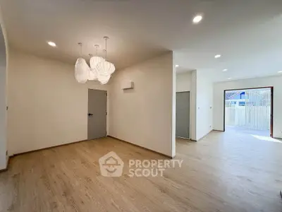 Spacious modern living room with elegant lighting and wooden flooring, perfect for family gatherings.