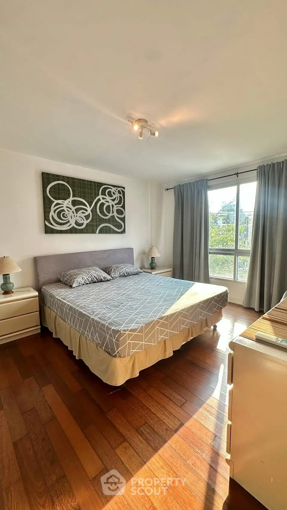 Spacious bedroom with modern decor and large window for natural light