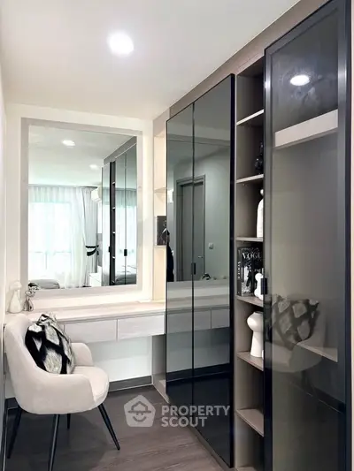 Stylish modern bedroom with sleek wardrobe and cozy seating area, perfect for urban living.