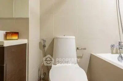 Modern bathroom with sleek fixtures and neutral tones, featuring a bathtub and contemporary design.