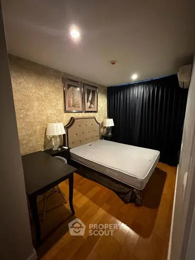 Cozy bedroom with elegant decor and wooden flooring, featuring a stylish bed and ambient lighting.