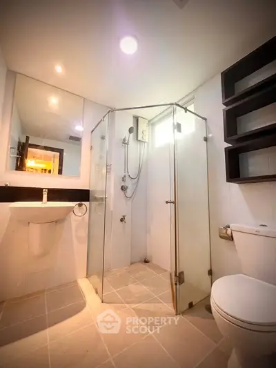 Modern bathroom with glass shower enclosure and sleek fixtures