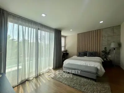 Spacious bedroom with large windows and modern decor, perfect for natural light lovers.