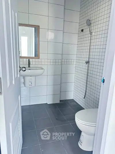 Modern bathroom with sleek tiles and minimalist fixtures in a contemporary home.