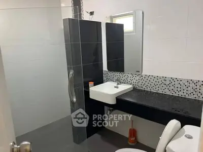 Modern bathroom with sleek black and white tiles and a stylish sink.