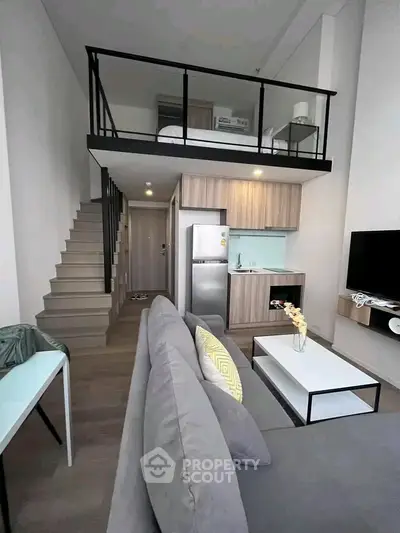 Modern loft apartment with stylish living area and mezzanine bedroom, featuring sleek kitchen and cozy decor.