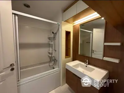 Modern bathroom with sleek fixtures, ample lighting, and a large mirror, perfect for a refreshing start to the day.