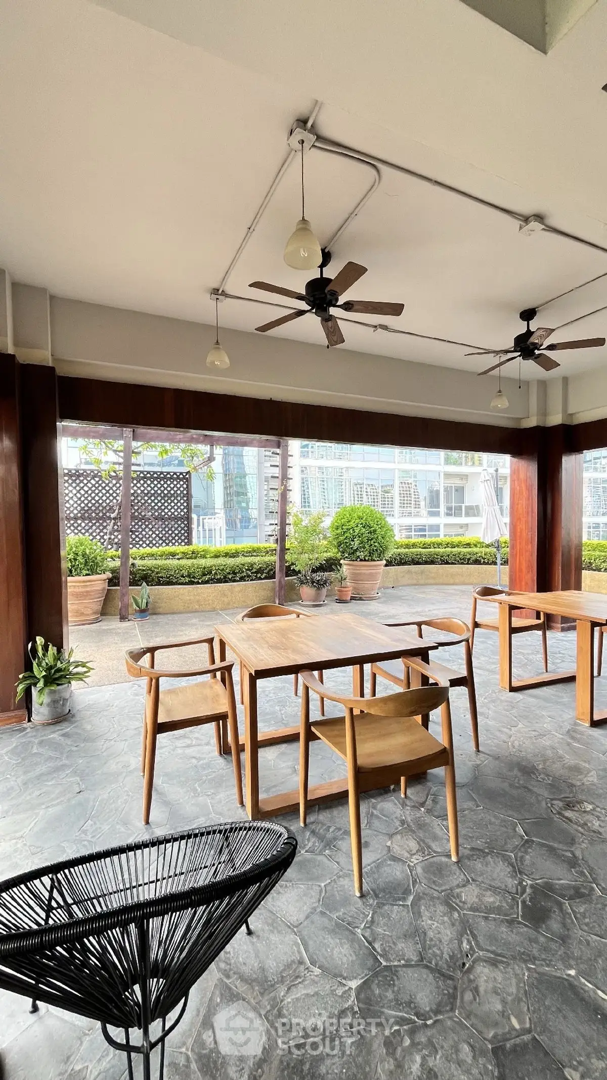 Spacious outdoor seating area with modern wooden furniture and garden view.