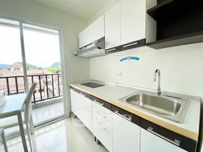 Modern kitchen with sleek cabinets and balcony view, perfect for culinary enthusiasts.