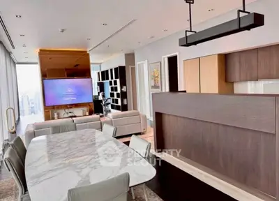 Luxurious open-plan living room with modern kitchen and marble dining table in high-rise apartment.