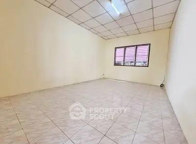 Spacious empty room with tiled flooring and large window