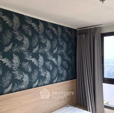 Stylish bedroom with modern wallpaper and large window offering natural light.