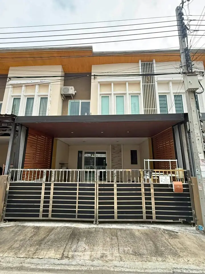 Modern townhouse exterior with gated entrance and contemporary design.