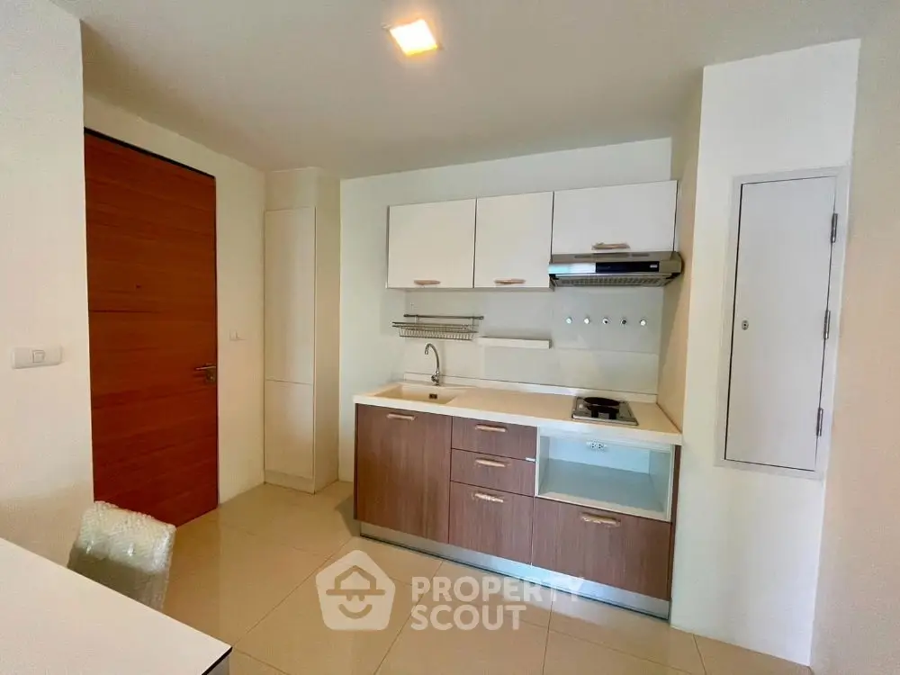 Modern compact kitchen with sleek cabinetry and gas stove in cozy apartment