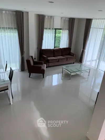 Spacious modern living room with large windows and elegant furnishings