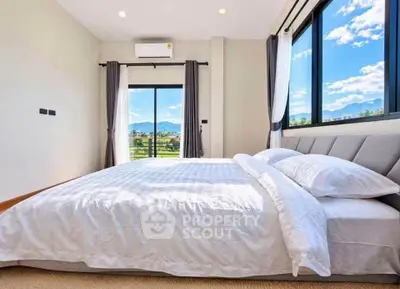 Spacious bedroom with large windows offering stunning mountain views